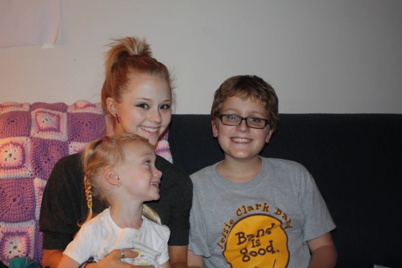 three children sitting next to each other smiling