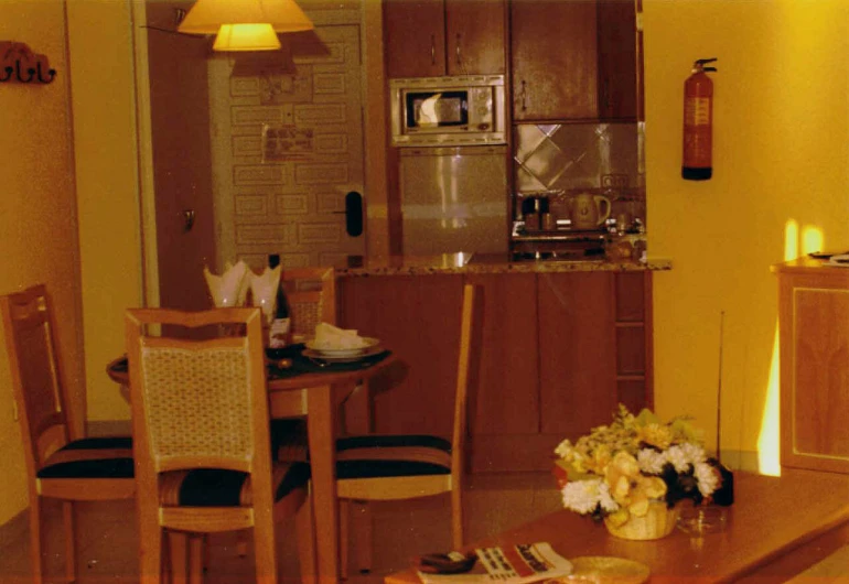 a kitchen with two chairs and a small table with flowers