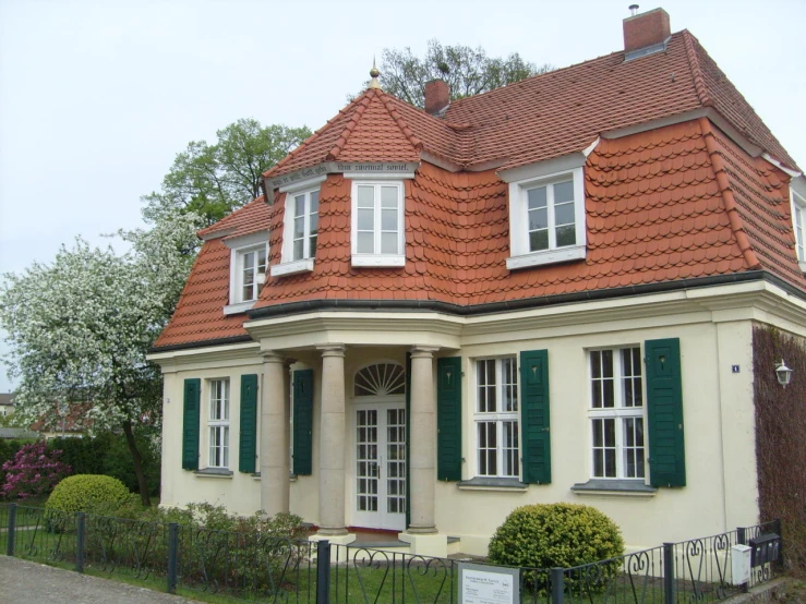 a white and orange house with green shutters