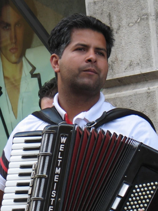 a man with a red tie holding a black accordion