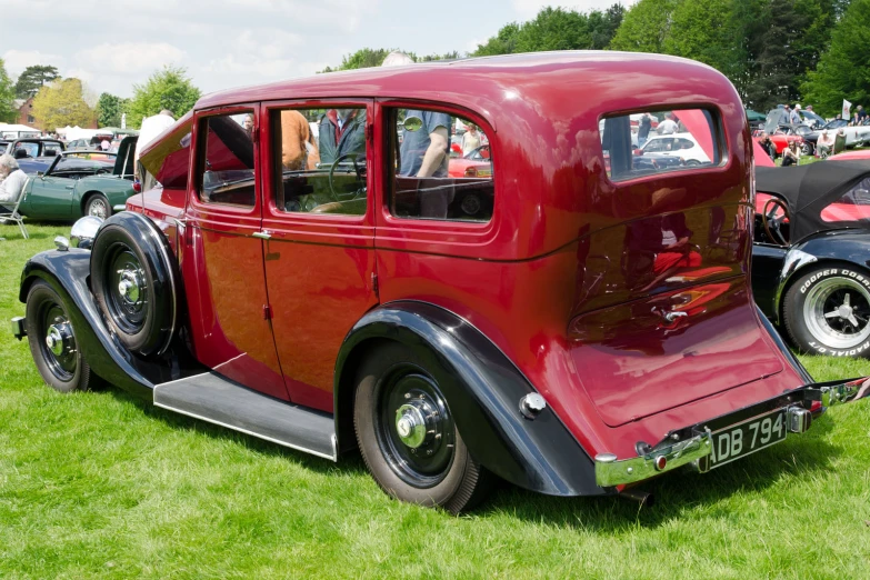 a very pretty old model car in a grass field