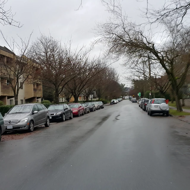 a large street with some parked cars and a building