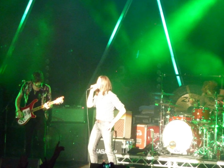 three men on stage with musical instruments