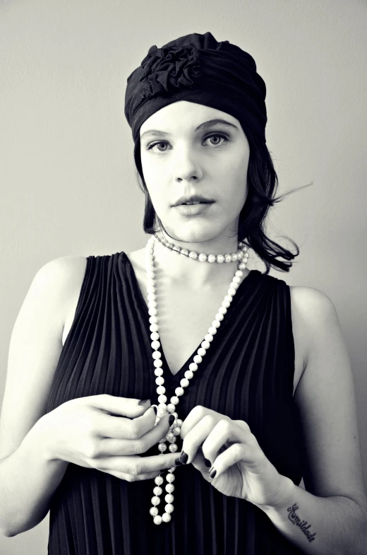 a woman poses wearing a necklace and hat