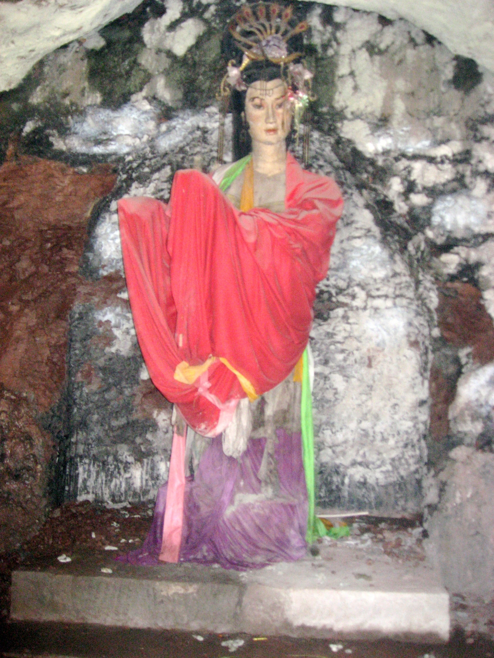 an old statue is wearing a colorful robe