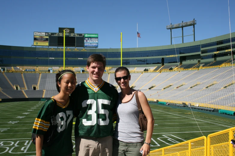 a couple and two girls posing on the football field