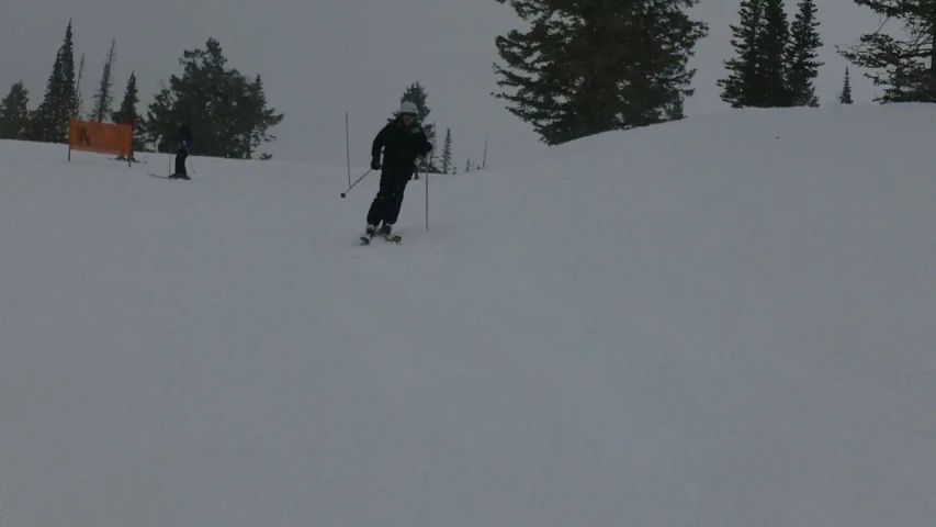 two people who are walking through snow on skis