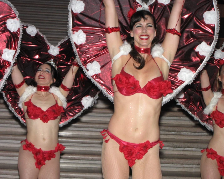 women dressed in red and white outfits with wings