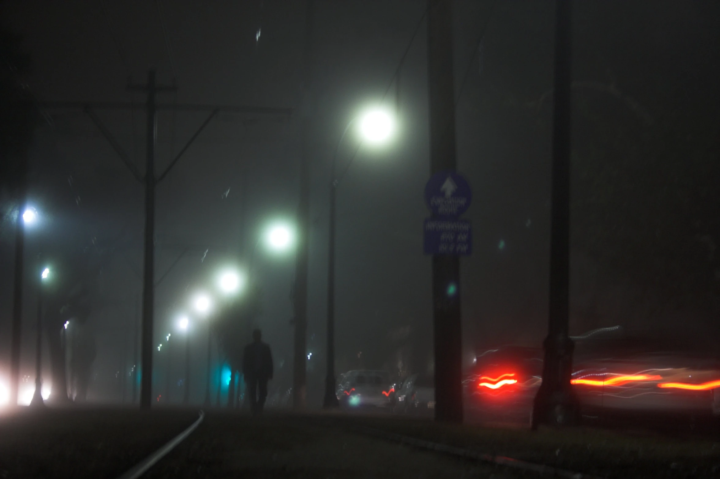 cars driving on the street at night in fog