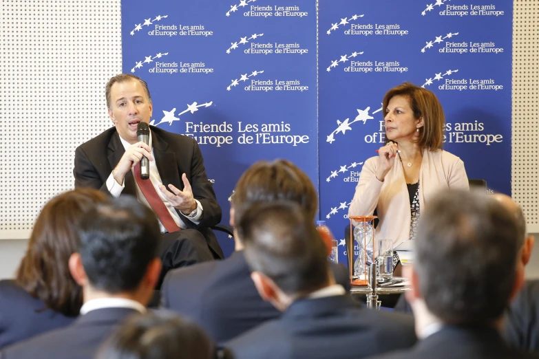 two men and one woman at a podium