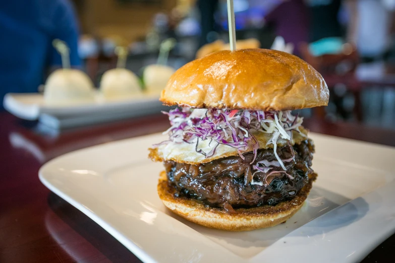 a meat covered burger on a bun with onions