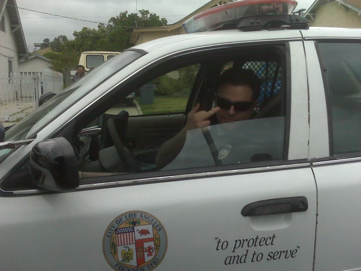 a woman is sitting in the drivers seat of a white police car