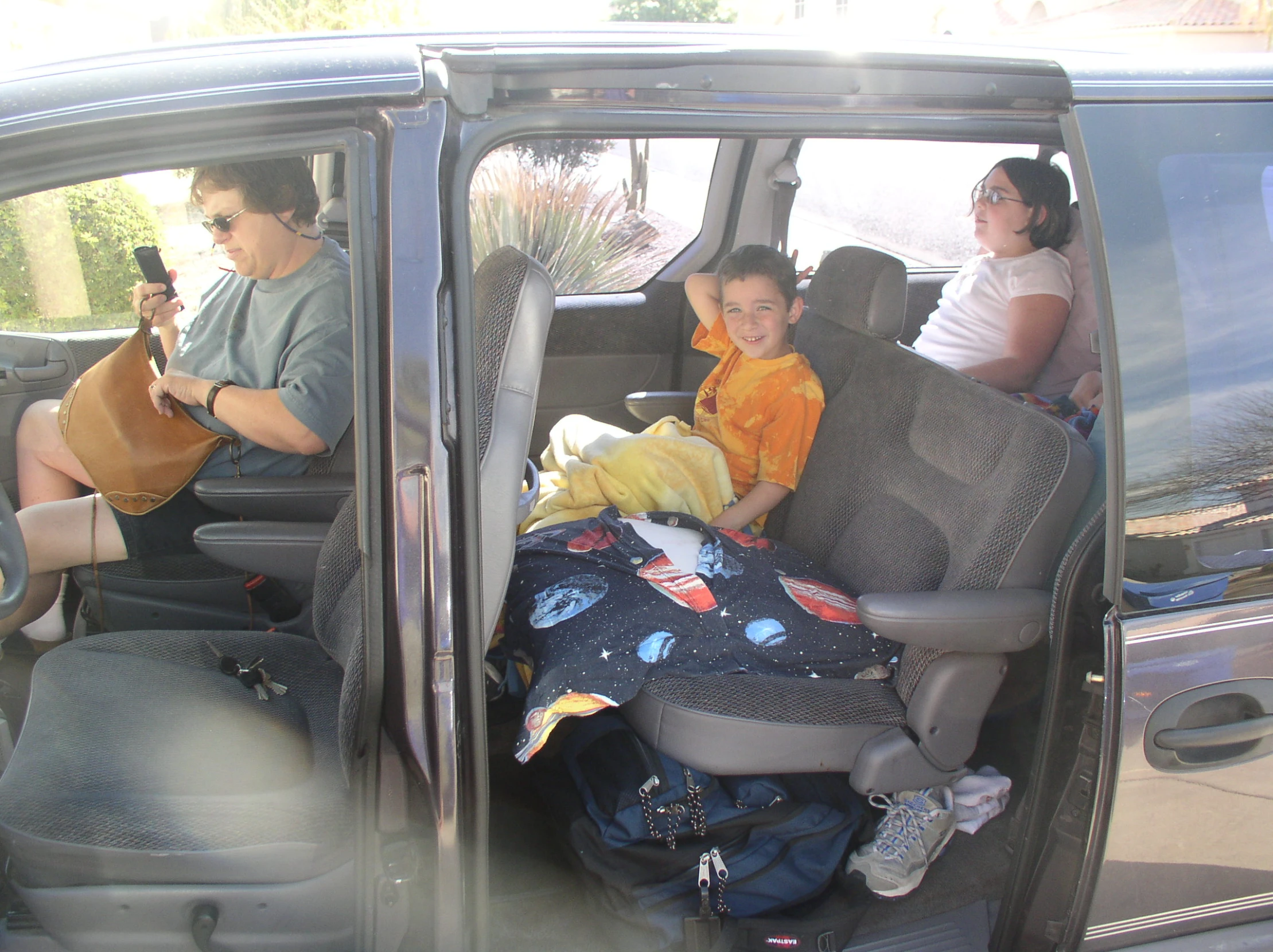 children sitting in back of van with the door open