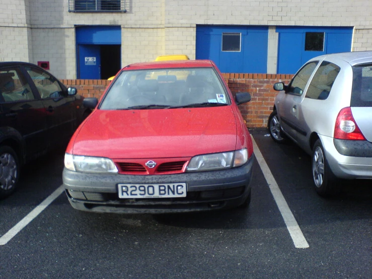 three cars are parked in a spot next to the building