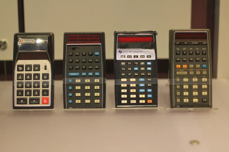 there are many different calculators and a clock on the counter