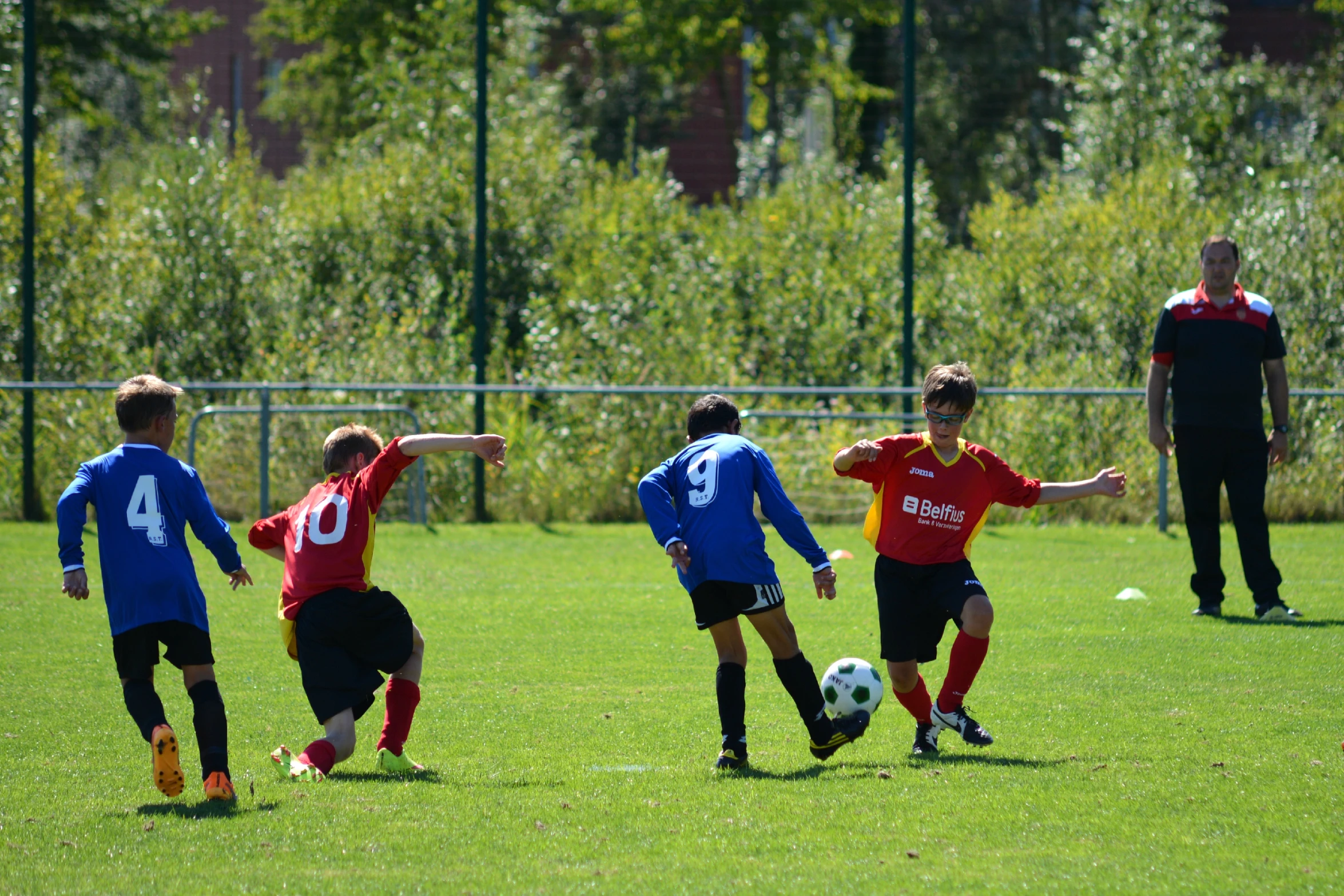 children are in the grass playing soccer against each other