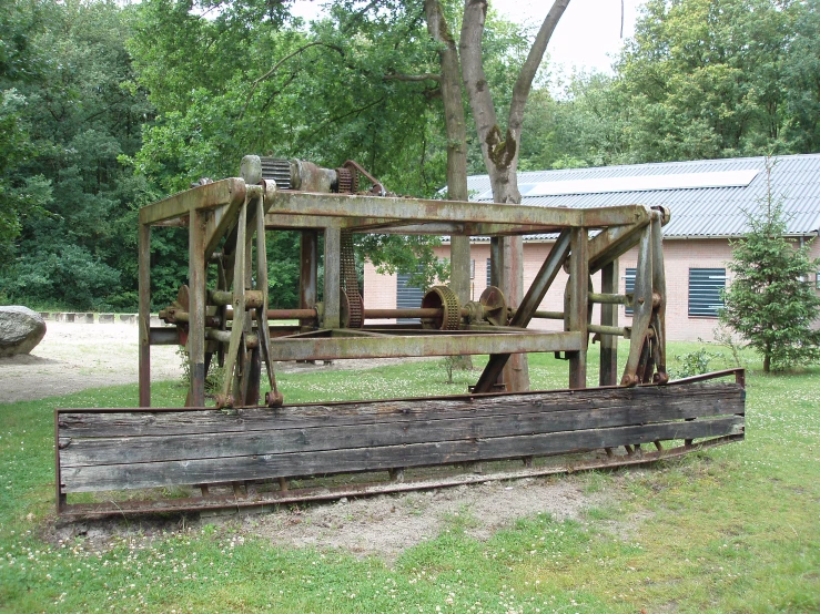 an old wooden structure near a tree in the yard