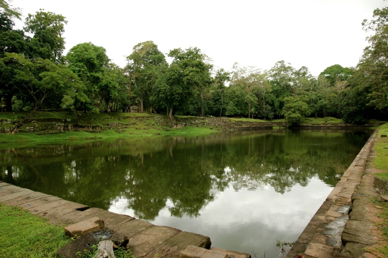 the pond is surrounded by stone and grass