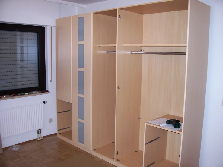 a closet with wood shelves and shelves next to a window