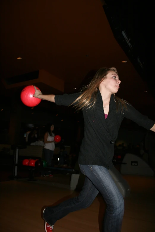 a woman juggling a ball while standing on a dance floor