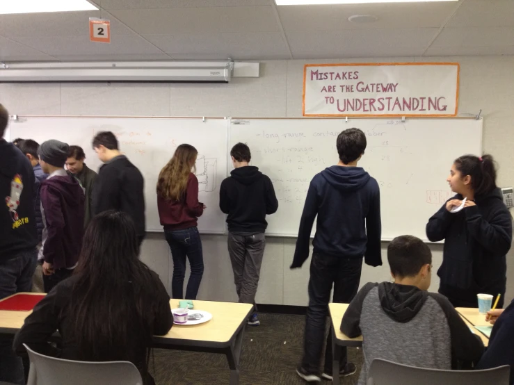 a group of people standing next to each other in front of a whiteboard