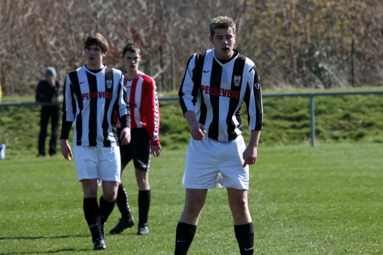 three soccer players are standing around the field