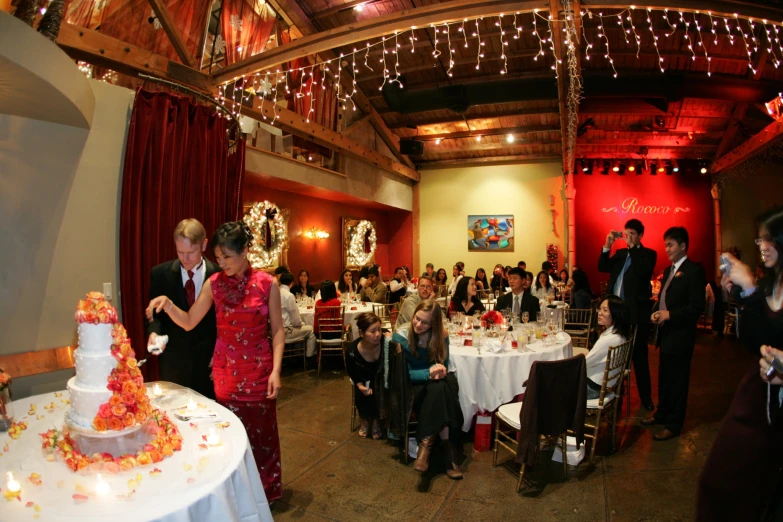 a couple getting married in front of a wedding cake