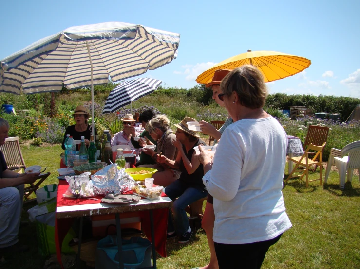 a group of people sitting around a table at an outdoor party