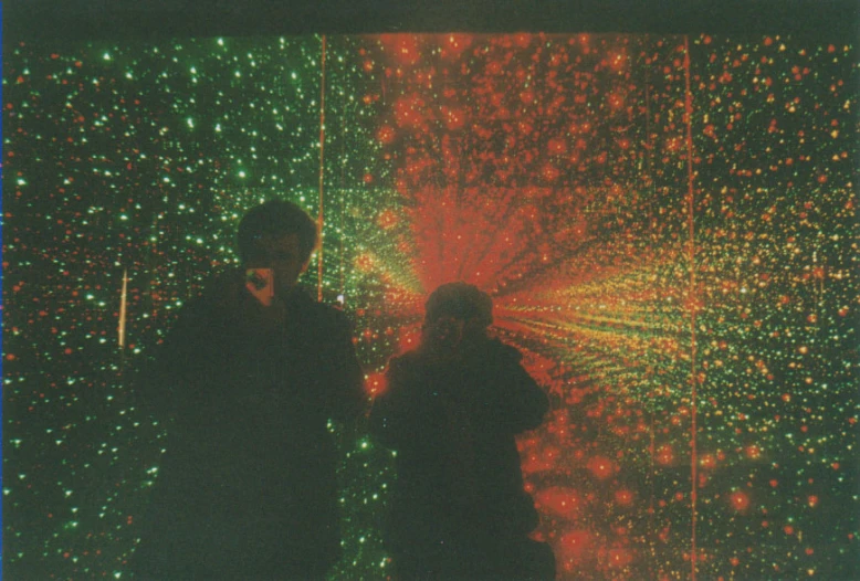 two people standing in front of lights that resemble fireworks