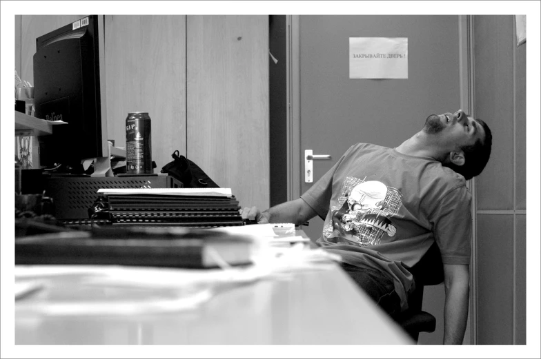 a man that is sitting down in front of a desk