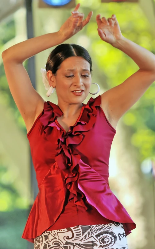 the woman is dancing in a red blouse