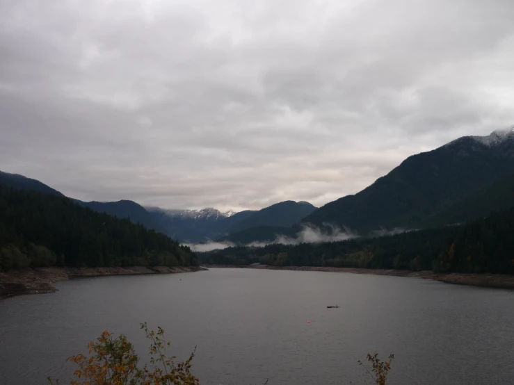 a body of water surrounded by mountains and forest