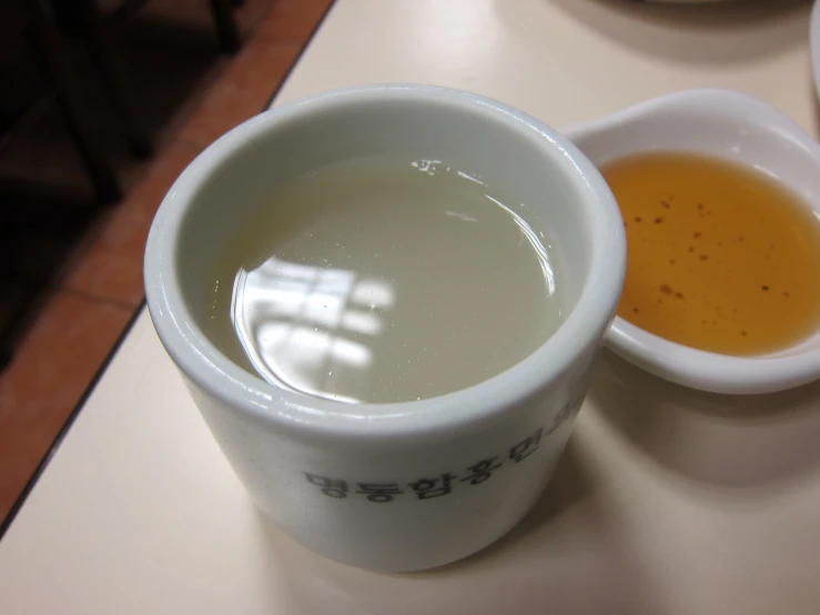 a cup of water and a small bowl of soup