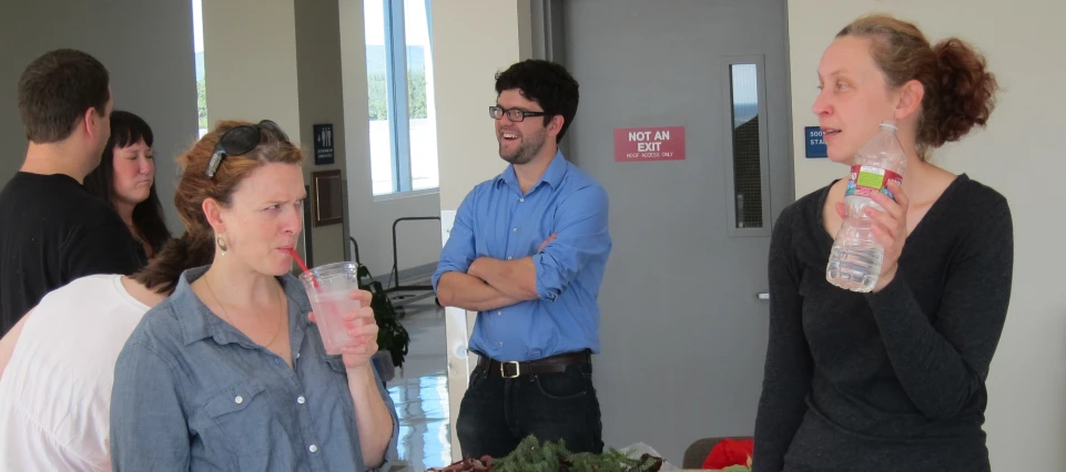 people standing in an office talking and drinking