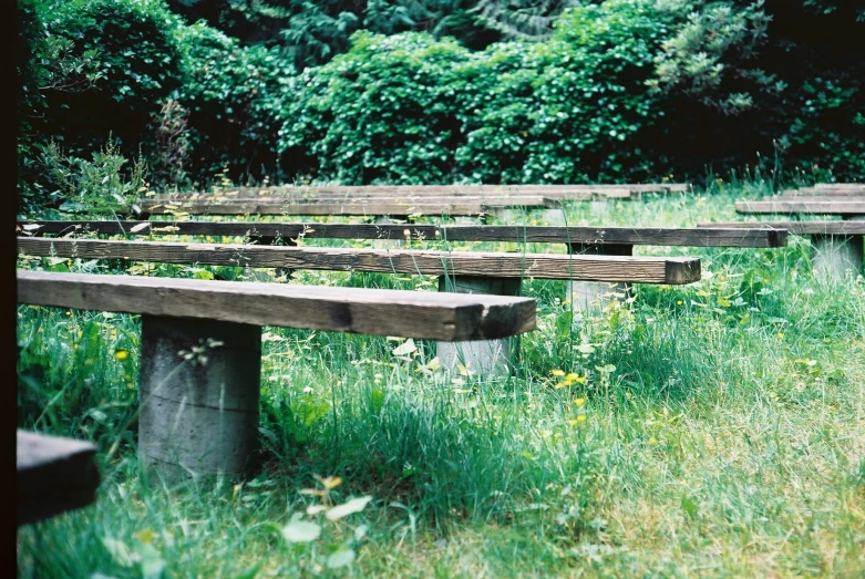 a bunch of wood benches sitting in a field