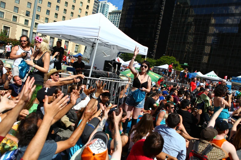 a woman in sunglasses dancing with other people surrounding her