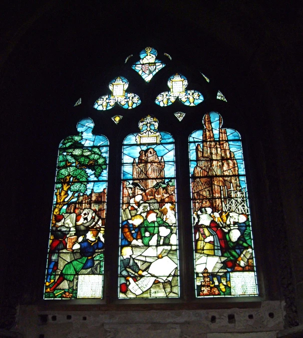 the stain glass window in the cathedral depicts a city scene