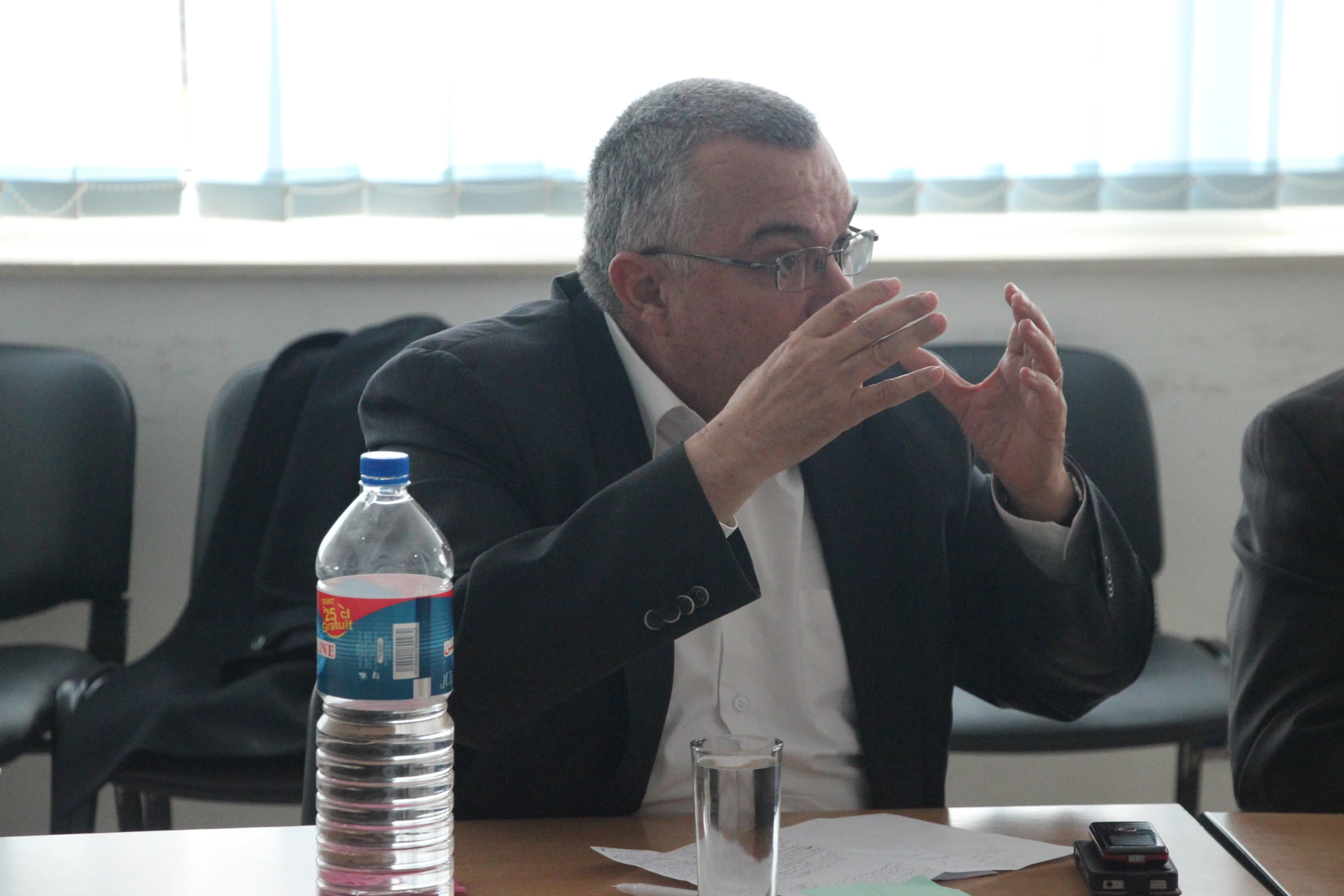 a man wearing glasses sits at a table