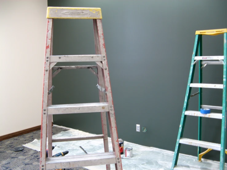 a room painted with gray and yellow with a ladder