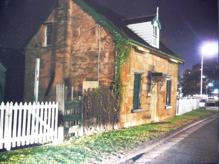 a brick house with an attached garden, and a picket fence