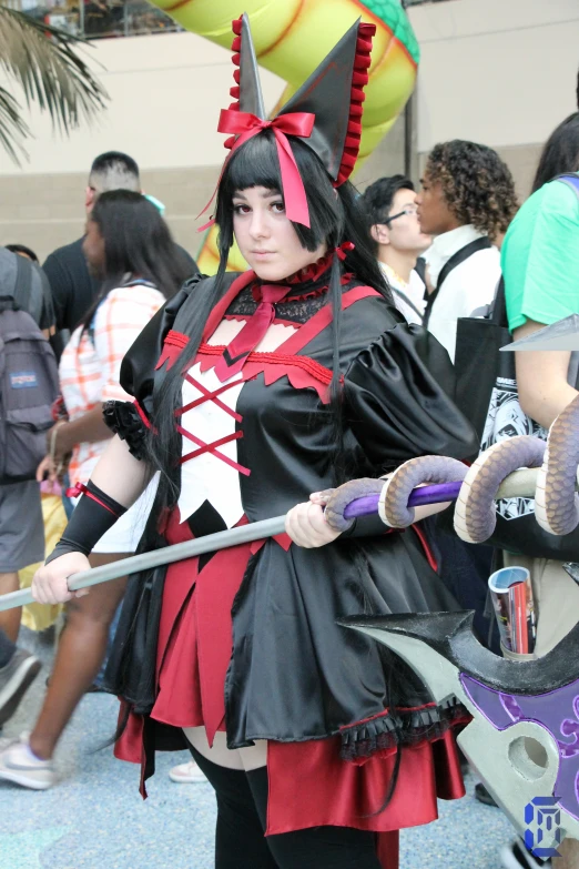 a woman in black is holding a large knife and an umbrella