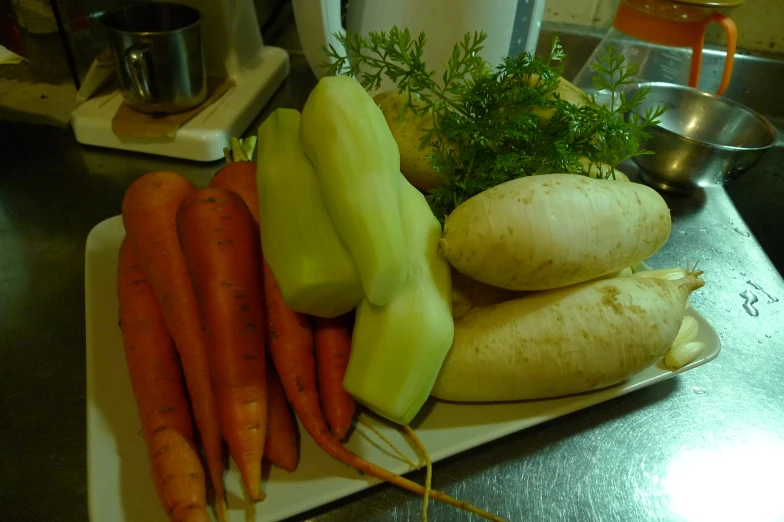 there are vegetables on a plate on the counter