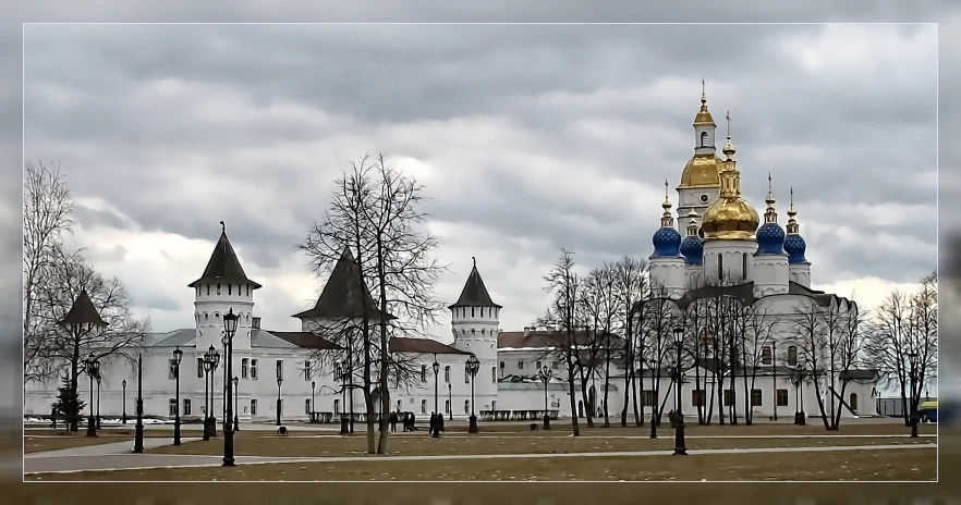 a large cathedral surrounded by bare trees and cloudy skies