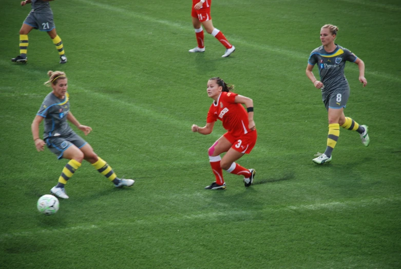 soccer players are running on a green field