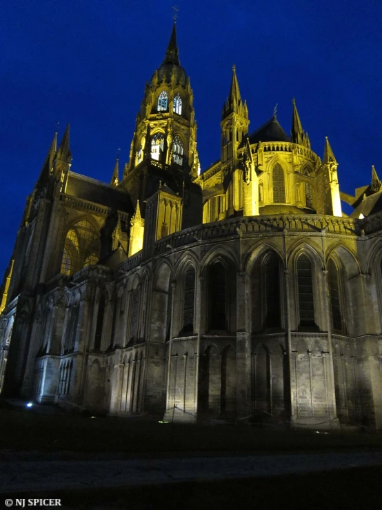 a nighttime image of a cathedral, the lights shining