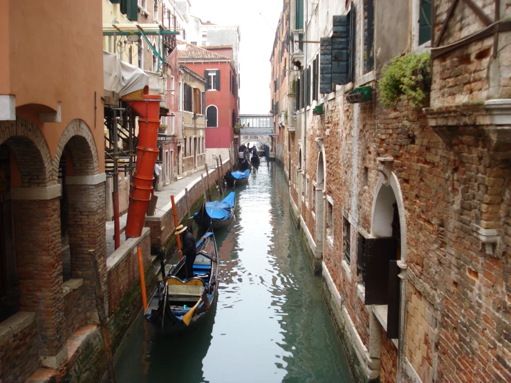 a narrow canal with several boats tied to the sides