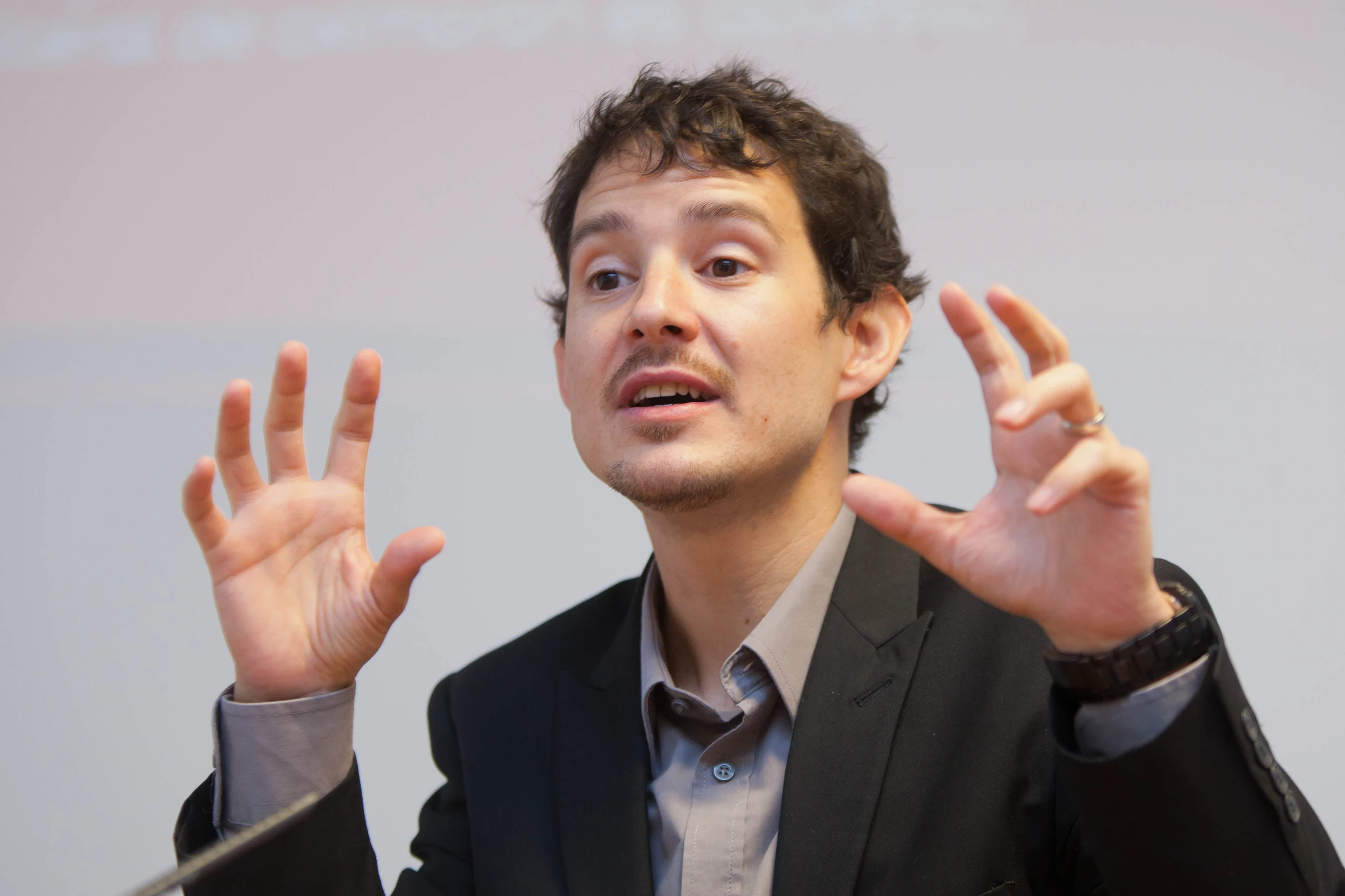 a man wearing a suit making the vulcan signs