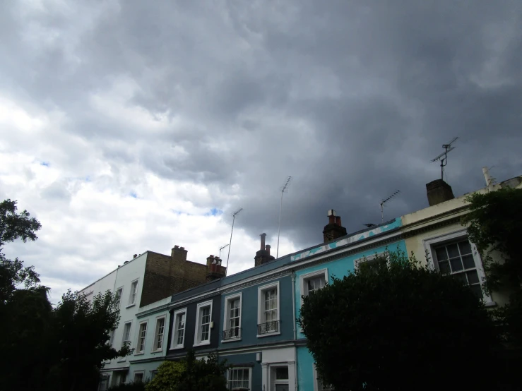 several blue buildings with chimneys and windows on top of them