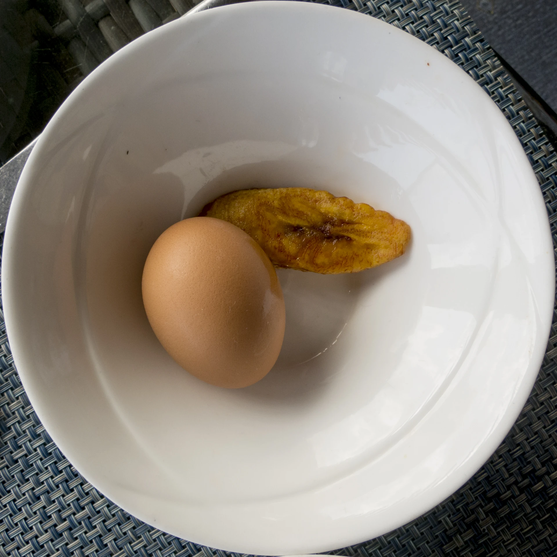 a half eaten banana and egg in a bowl