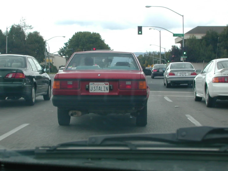 some cars driving down a street on a cloudy day